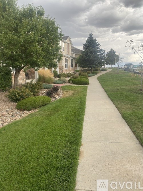 A sidewalk in a residential area with a house in the background.