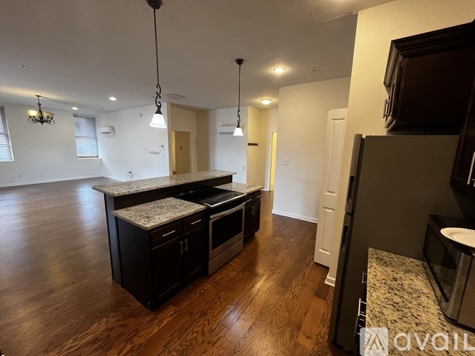 A kitchen with dark wood cabinets and a granite countertop.