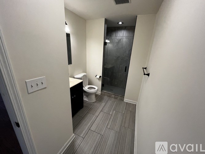 A bathroom with a toilet, sink, and tiled floor.