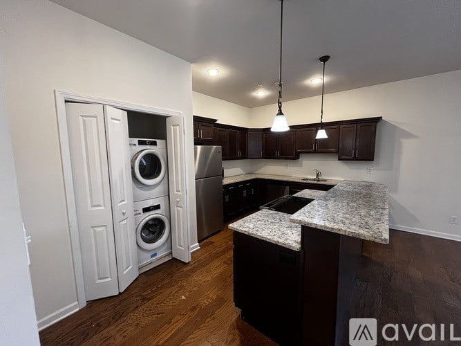 A kitchen with a washer and dryer built into the cabinetry.