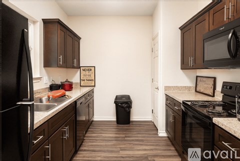A kitchen with dark wood cabinets and appliances.