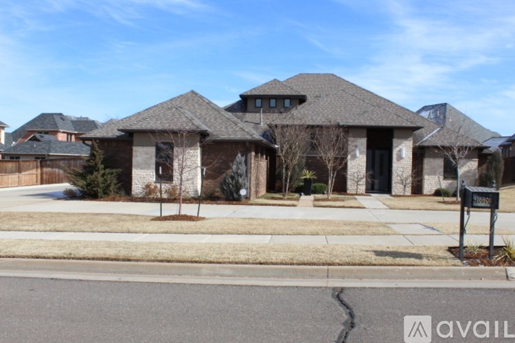 A house with a brown roof and a driveway in front.