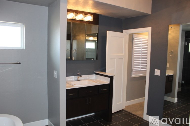 A bathroom with a sink, mirror, and toilet.