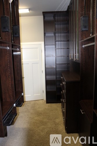 A hallway with a white door and a carpeted floor.