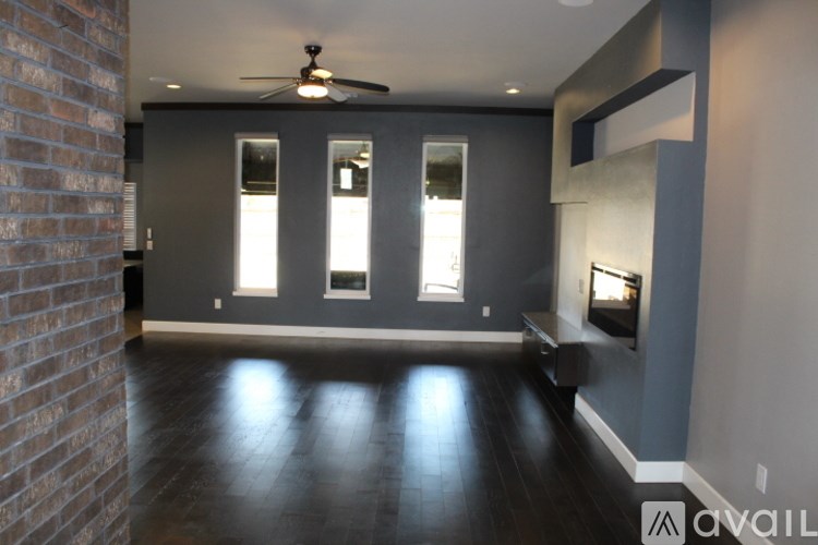 A room with a ceiling fan and a brick wall.