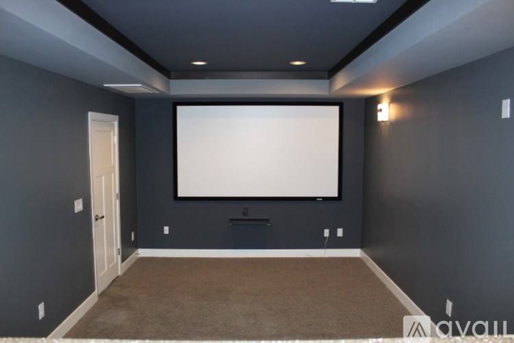 A large screen in a room with grey walls.