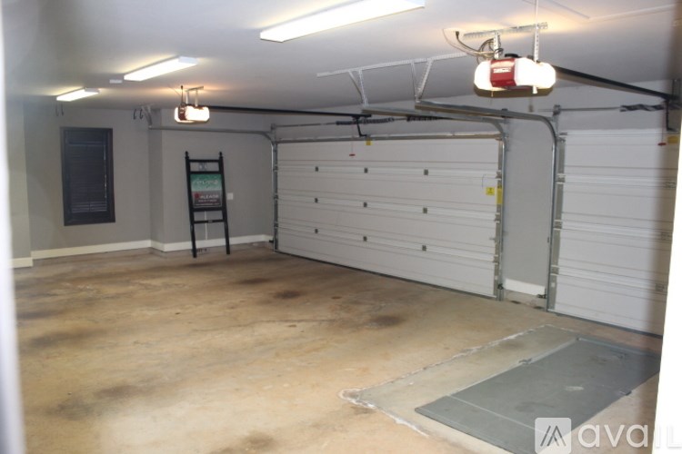 A garage with a white door and a black ladder.