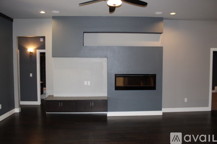 A modern living room with a fireplace and a ceiling fan.