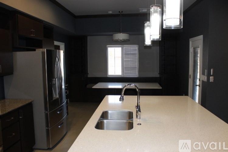 A kitchen with a sink and a refrigerator.