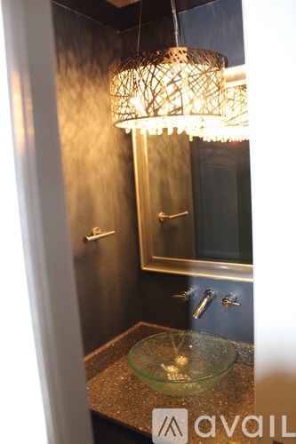 A bathroom with a glass counter top and a wall-mounted mirror.