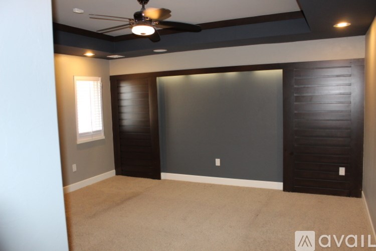 A room with a ceiling fan and a window.