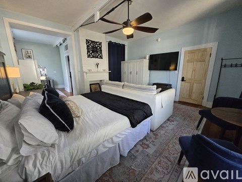 A bedroom with a four poster bed and a painting on the wall.