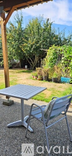 A patio with a table and chairs under a roof.