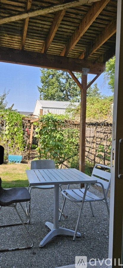 A patio with a table and chairs under a roof.