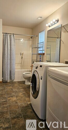 A bathroom with a washer and dryer in it.