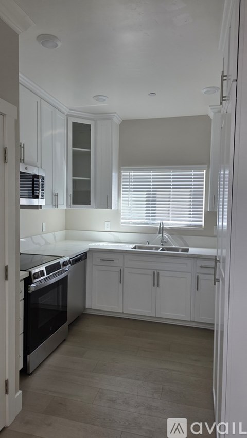 A kitchen with white cabinets and a stainless steel oven.