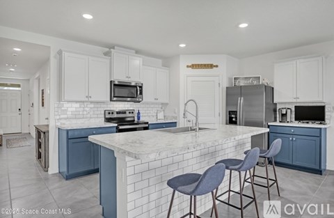 A kitchen with a white counter top and blue cabinets.