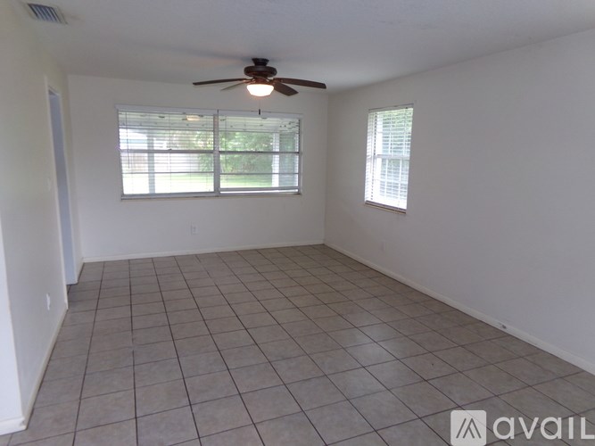 A room with a ceiling fan and tiled flooring.