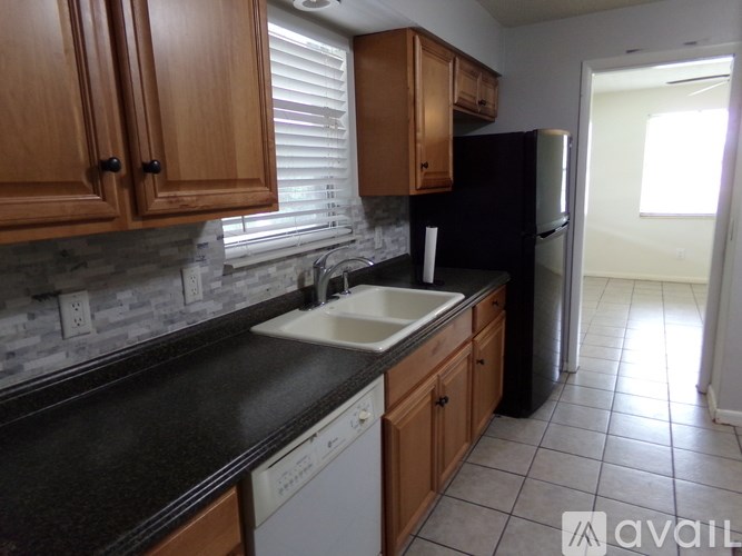 A kitchen with wooden cabinets and a black countertop.