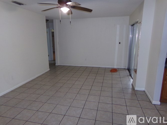 A room with a ceiling fan and tiled floor.