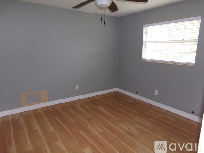 A room with wooden flooring and a ceiling fan.