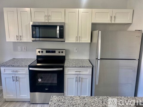 A kitchen with white cabinets and a granite countertop.