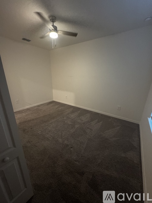 A room with a carpeted floor and a white door.