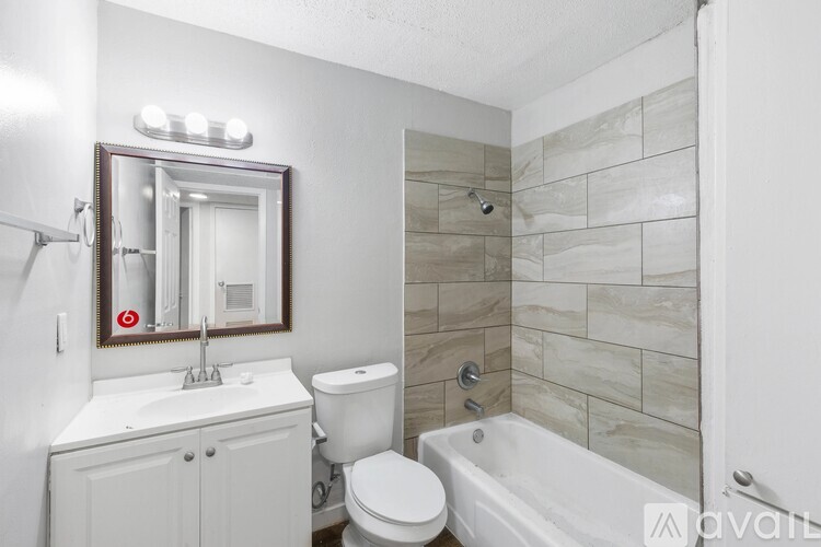 A bathroom with a white toilet, sink, and bathtub.