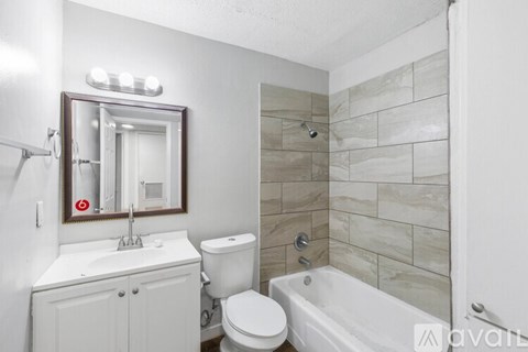 A bathroom with a white toilet, sink, and bathtub.