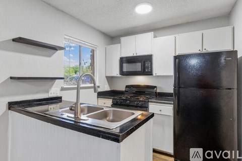 A kitchen with black countertops and white cabinets.