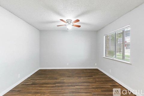A room with a ceiling fan and a window.