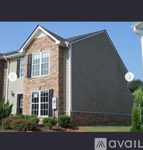 A house with a grey roof and a brick chimney is available for sale.