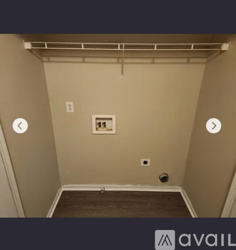 A room with a picture on the wall and a vent on the ceiling.