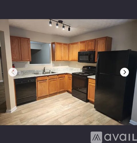 A kitchen with wooden cabinets and black appliances.