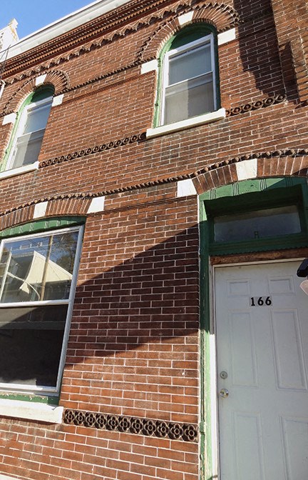 A red brick building with a white door and windows.