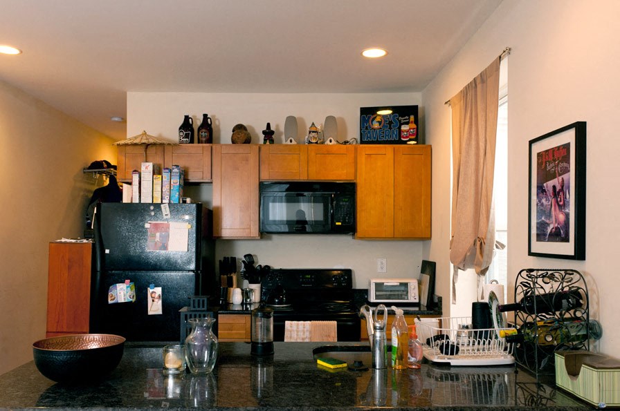 A kitchen with black appliances and wooden cabinets.