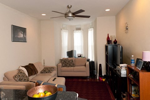 a living room filled with furniture and a ceiling fan