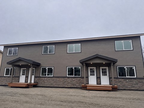 A grey house with a white door and windows.