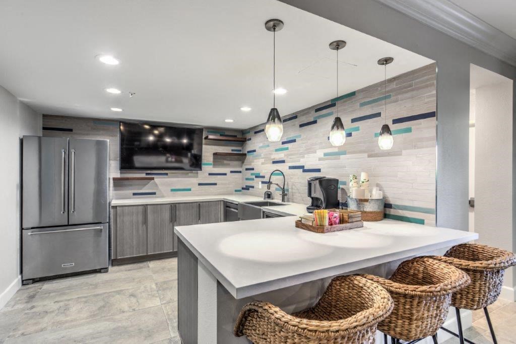 a kitchen with stainless steel appliances and a counter with three stools