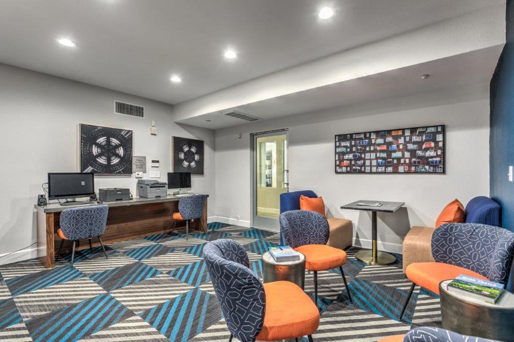 a lobby with chairs and a desk with a computer