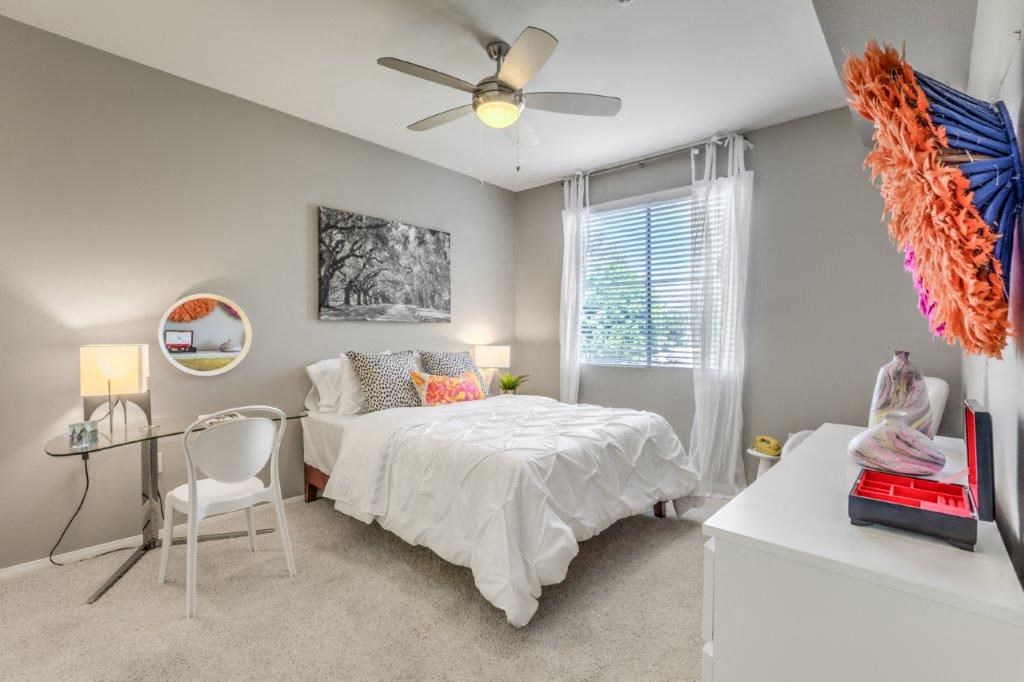 a bedroom with a bed and a ceiling fan