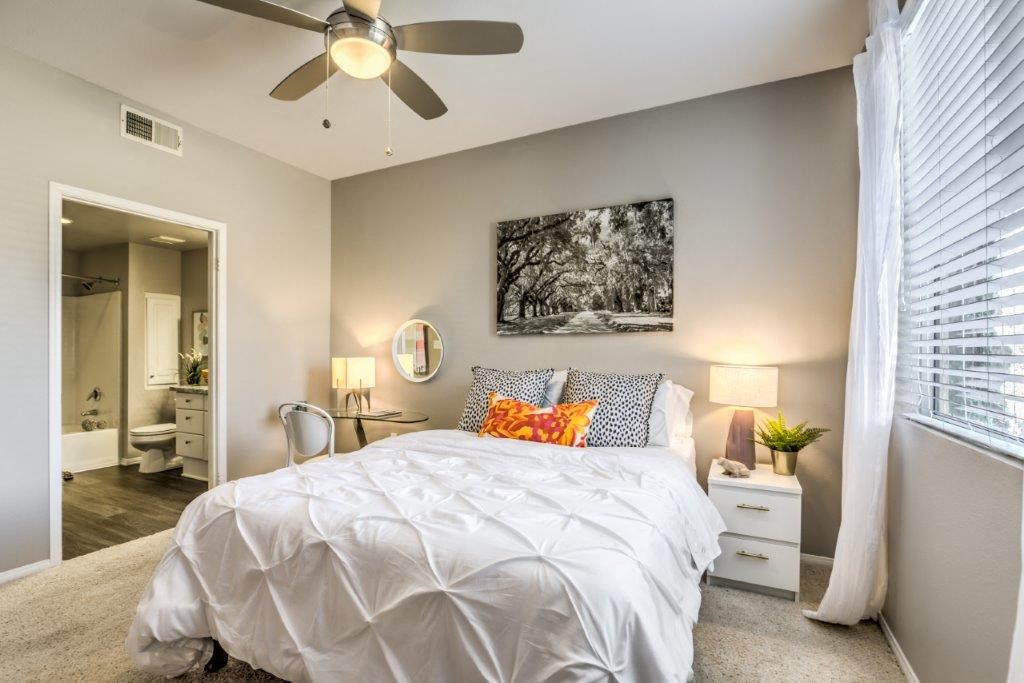 a bedroom with a bed and a ceiling fan