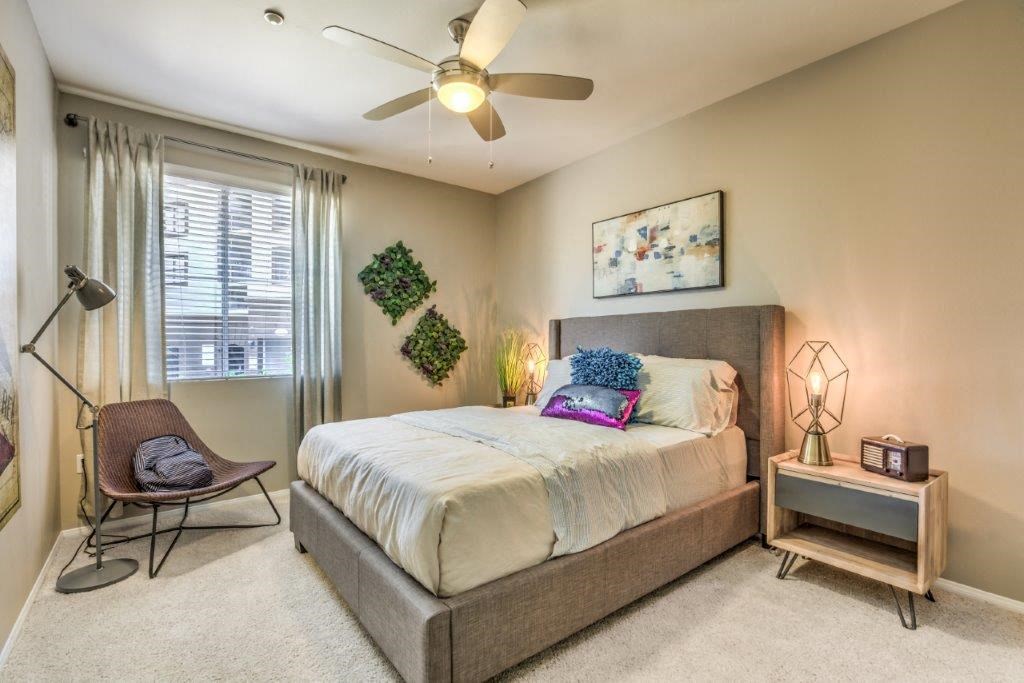 a bedroom with a bed and a ceiling fan