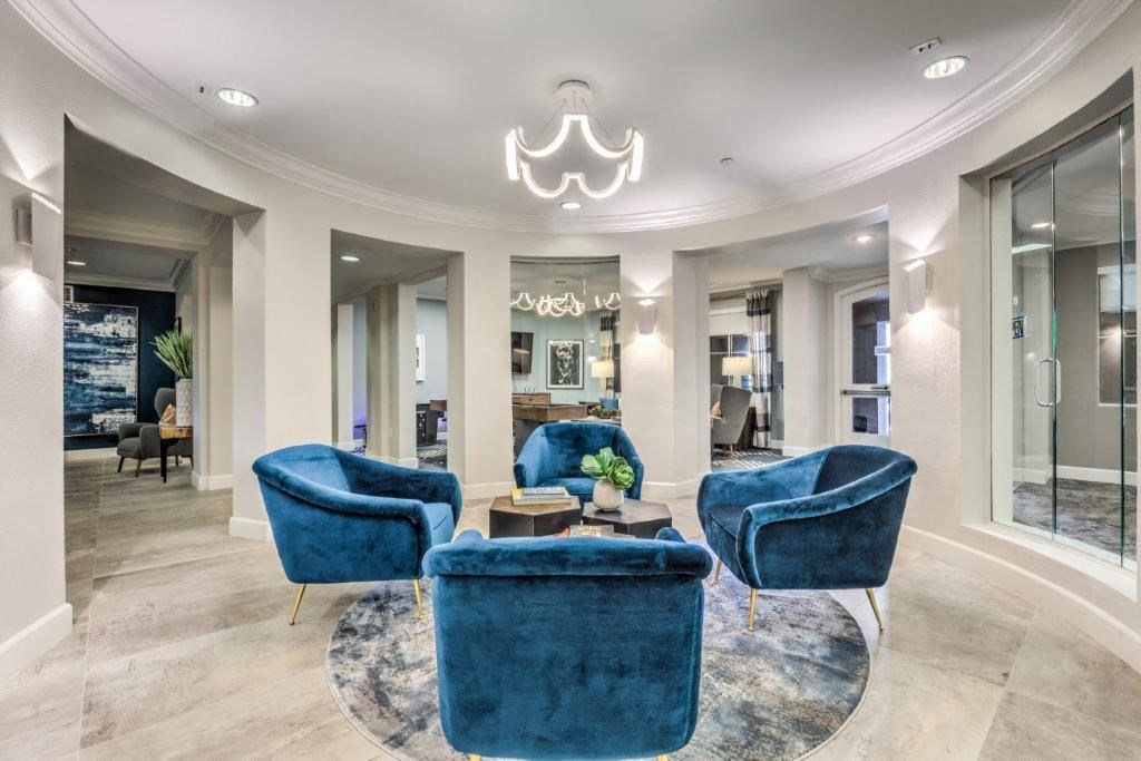 a living room with blue chairs and a chandelier