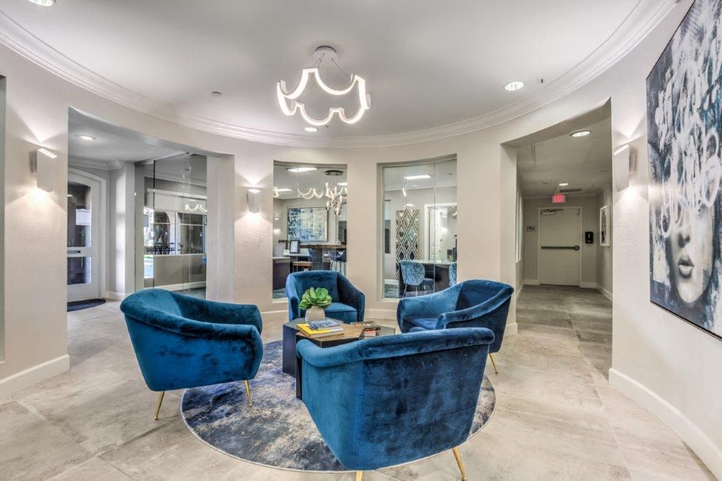 a living room with blue chairs and a chandelier