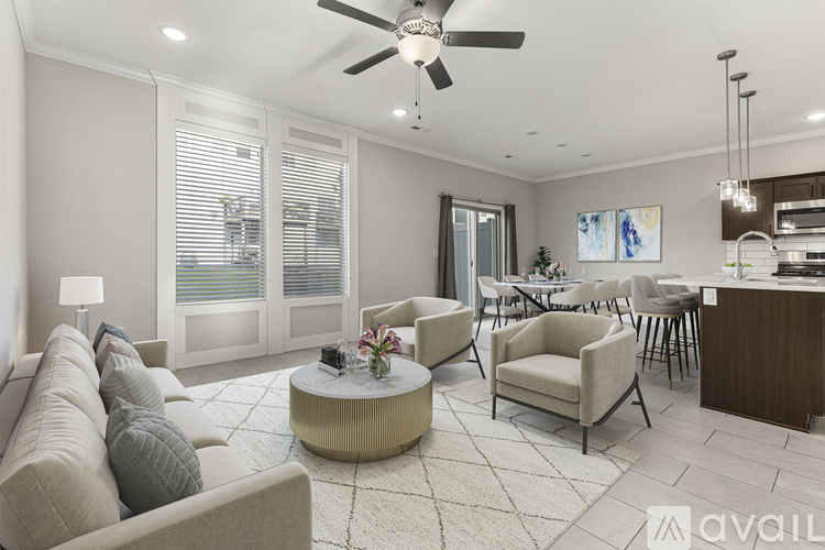 A living room with a beige sofa, a coffee table, and a ceiling fan.