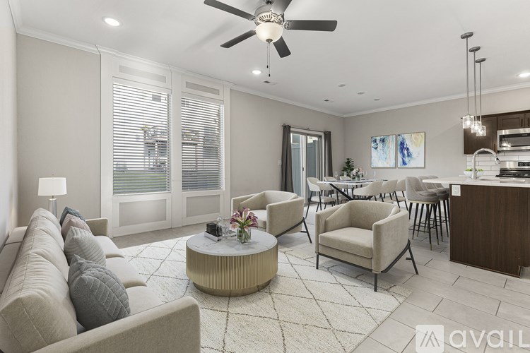 A living room with a beige sofa, a coffee table, and a ceiling fan.