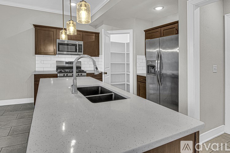 A kitchen with a granite countertop and stainless steel appliances.