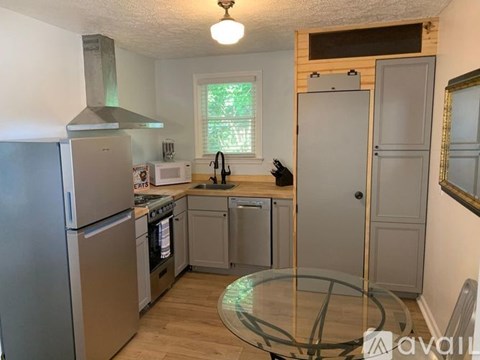 A kitchen with a refrigerator, oven, and sink.