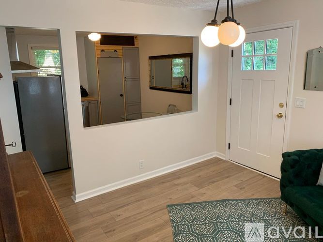 A living room with a green couch and a fridge.